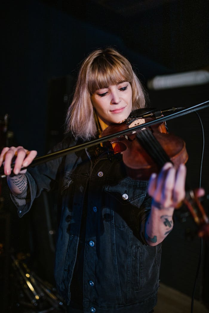 A tattooed musician plays the violin passionately, creating a dynamic musical atmosphere.